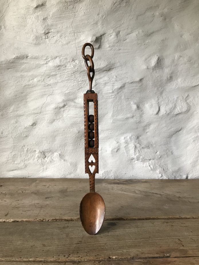 An original Welsh love spoon, dated 1838. A beautifully carved sycamore love spoon carved with a double heart, a linked chain, chip carving, balls in cage and very unusually a date.